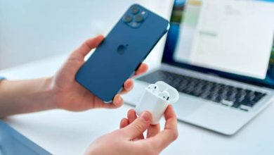 airpods in their case next to iphone